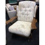 A button upholstered wing-back rocking chair with loose cushions, having spindle back and shaped