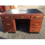 A 50s mahogany kneehole desk by Baldock & Sons, the moulded caddy top with writing surface above