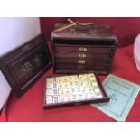 A boxed Chinese mah-jong set, the case with brass mounts containing five drawers of counters, winds,