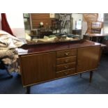 A 60s Italian walnut sideboard, with mirror back above glass top, having four central drawers