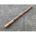 A 4ft Australian didgeridoo, the tubular instrument with stylised painted and carved decoration.