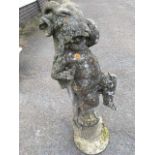 A nineteenth century composition stone figure of a cherub with rams skin cloak having lizard on