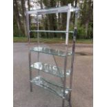 A modern chrome rectangular whatnot with waisted frame supporting five glass shelves.