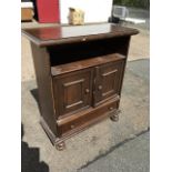 A stained side cabinet with moulded top above an open compartment and panelled door cupboard, with