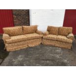 A pair of upholstered sofas with loose cushions & covers, raised on casters, a two-seater and a