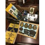 A collection of military cloth badges, some in album, some framed, civil defence, epaulettes,