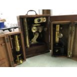 Three mahogany cased nineteenth century microscopes, no makers names evident, the largest on wood