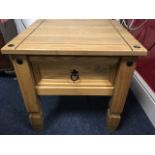 A modern square pine table of bolted construction with panelled drawer, raised on column legs.