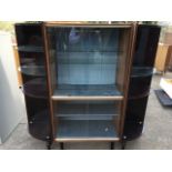A 70s Italian display unit with sliding glass doors enclosing shelves flanked by two quarter