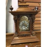 A large Edwardian walnut bracket clock, the architectural case with moulded cornice beneath pediment