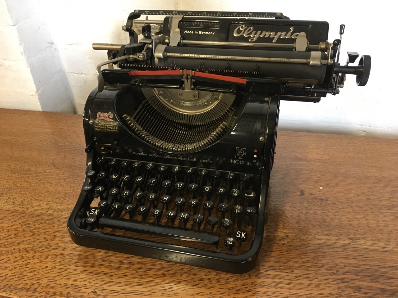 A German Olympia mechanical typewriter, the metal framed model 8 machine with Lows retail label.