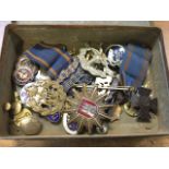 A rectangular tin box containing medals, tie pins, some enamelled, badges, some military, two with