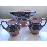 A pair of Maling pink storm lustre jugs with scrolled handles; and a matching Maling oval cone vase.