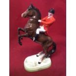 A Beswick huntsman & rearing horse, decorated in high gloss polychrome enamels on rounded plinth -