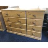 A pine chest of eight drawers mounted with knobs, supported on a moulded plinth.