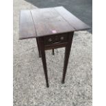 A small Georgian mahogany table inlaid with shell paterae, having narrow drop-leaves and oak lined