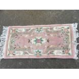 A Chinese thick pile wool rug woven in the floral famile rose style pink pastel palette.