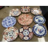 A set of five circular Imari scalloped plates decorated in the traditonal brick-red, blue and