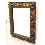 An Italian carved giltwood mirror, the rectangular frame with pierced leaf scrolled decoration.