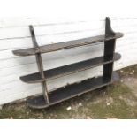 A nineteenth century hanging pine shelf, with three rounded moulded platforms, ebonised and gilded.