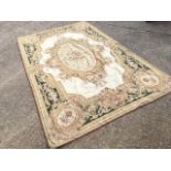 An Aubusson tapestry wool rug, woven with oval floral medallion having four pendants on ivory field,