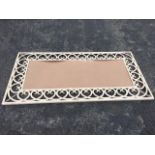 A large 6ft wrought iron frame, formerly mirrored, the painted metal border with interlaced scrolled