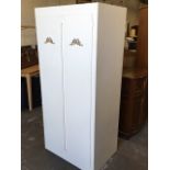 A painted cupboard, the doors with applied gilt ribbon bow decoration enclosing shelves.