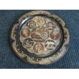 A circular Egyptian copper platter with inlaid neillo decoration of medallions, framing a chariot,