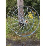 A pair of large spoked wheels from an agricultural threshing machine, with channelled rims and