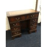 A reproduction mahogany kneehole desk, the rectangular top with gilt tooled skiver above two