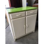 A painted kitchen cabinet with enamelled top above two frieze drawers and cupboards, with plinth