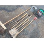 Various garden tools including a spade, hoes, a fork, a yard brush, a galvanised mop bucket, a