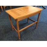 A 70s teak coffee table by Schreiber, the elliptical rectangular top on turned column legs joined by