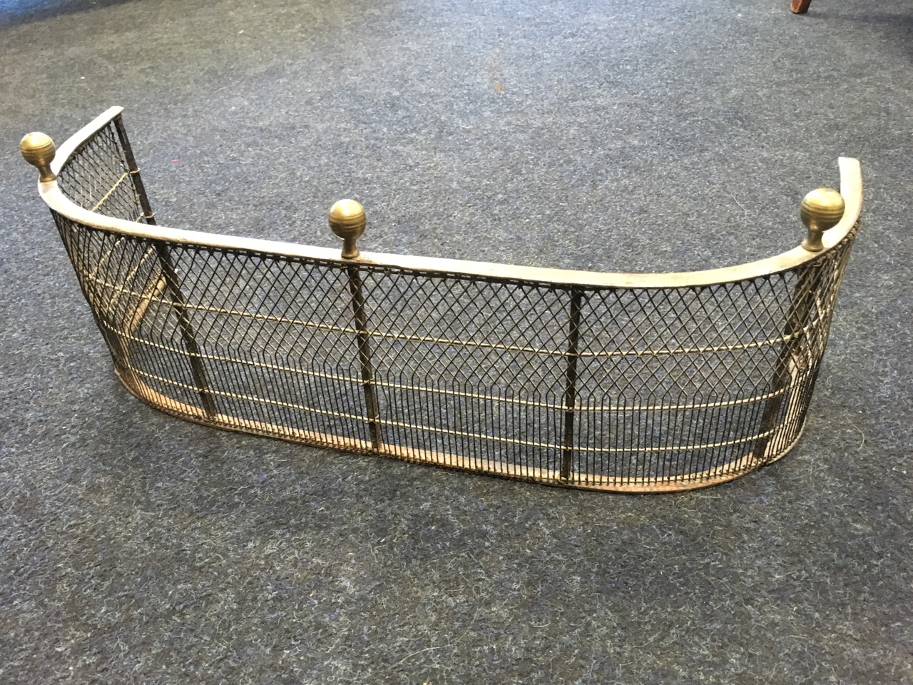 A small nineteenth century 'D' shaped fender with grill panels to frame, surmounted by three brass