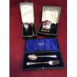 Three hallmarked silver cased christening sets - a spoon & fork, a tankard and an egg cup & spoon,