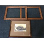 A pair of large late Victorian carved oak frames; and a framed photograph of a thatched pub titled