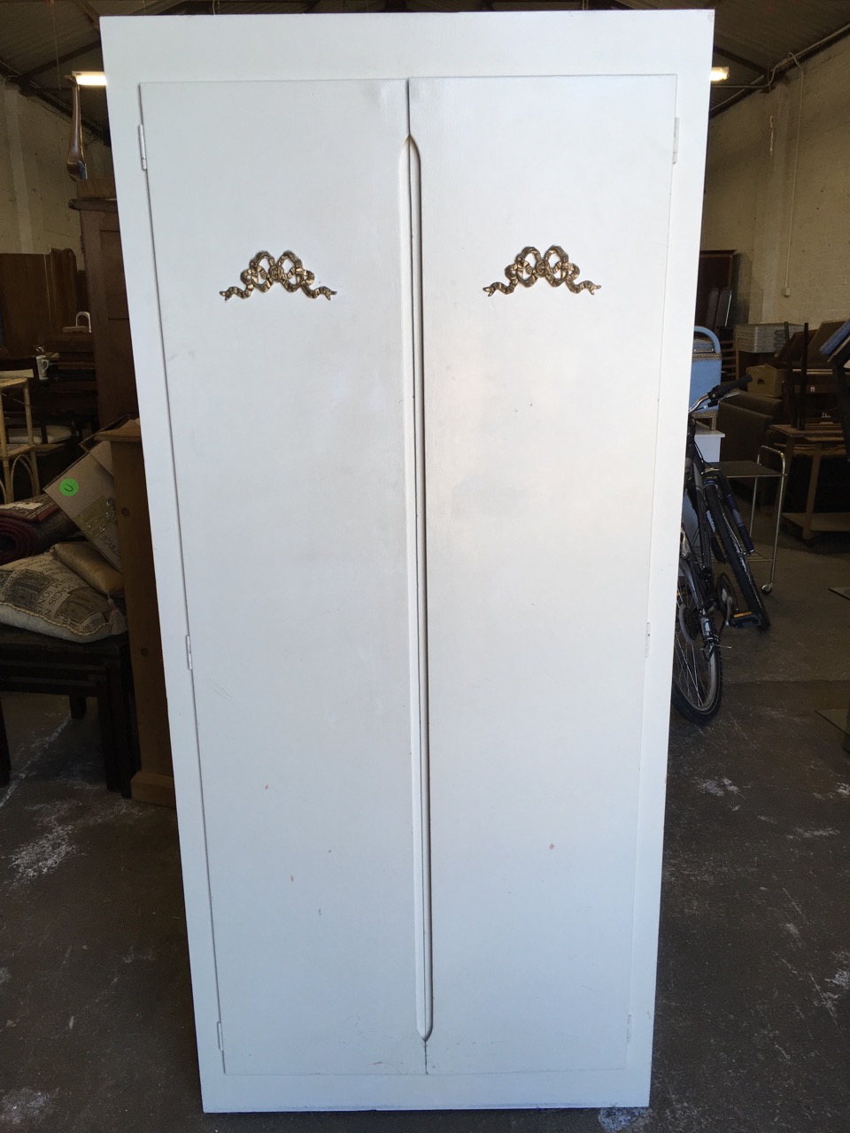 A painted cupboard, the doors with applied gilt ribbon bow decoration enclosing shelves. - Image 6 of 6