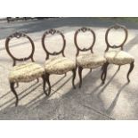 A set of four Victorian mahogany balloon back dining chairs, with pierced carved decoration to backs