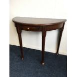 A 'D' shaped mahogany hall table, the moulded top above a small frieze drawer, raised on tapering