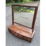 A bowfronted nineteenth century mahogany dressing table mirror, the rectangular plate in reeded