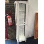 A painted glazed cupboard, wired with electric light above glass shelves, having tongue & grooved