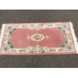 A Chinese famile rose style wool rug, woven with thick pile having pastel floral medallion &