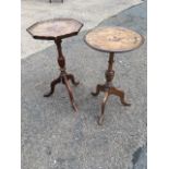 Two mahogany wine tables on columns with tripartite legs, one circular with inlay, the other