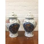 A pair of Chinese porcelain baluster jars and covers, the domed lids and bodies enamelled with