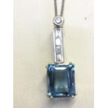 An 18ct gold emerald cut aquamarine & diamond pendant, the large baguette cut aquamarine stone of