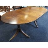 A Georgian style twin pedestal mahogany dining table, the top with reeded edge on barrel turned