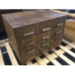 An Edwardian oak cabinet of twelve small drawers, the drawers mounted with brass label holders and