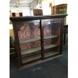 A Victorian glazed cupboard with scumbled decoration, having moulded cornice above a pair of sliding