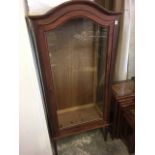 A glazed vitrine with arched moulded cornice above a glass dowel jointed cupboard door, with glass