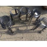 Fifty circular iron pot stands, each with round apertures on three legs with scrolled feet. (50)